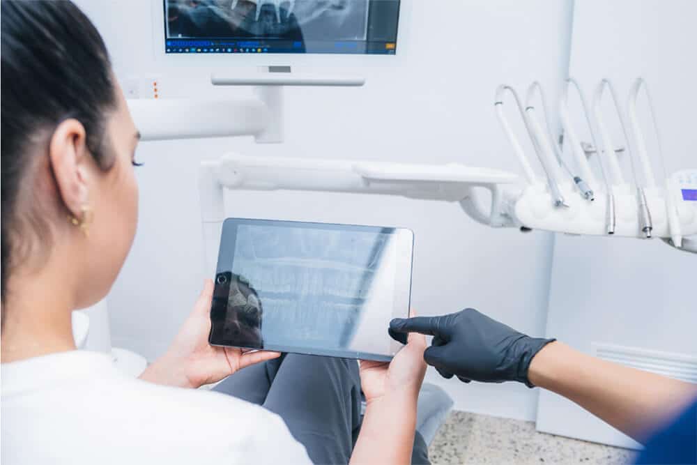 doctor is showing dental x-ray scans to a patient