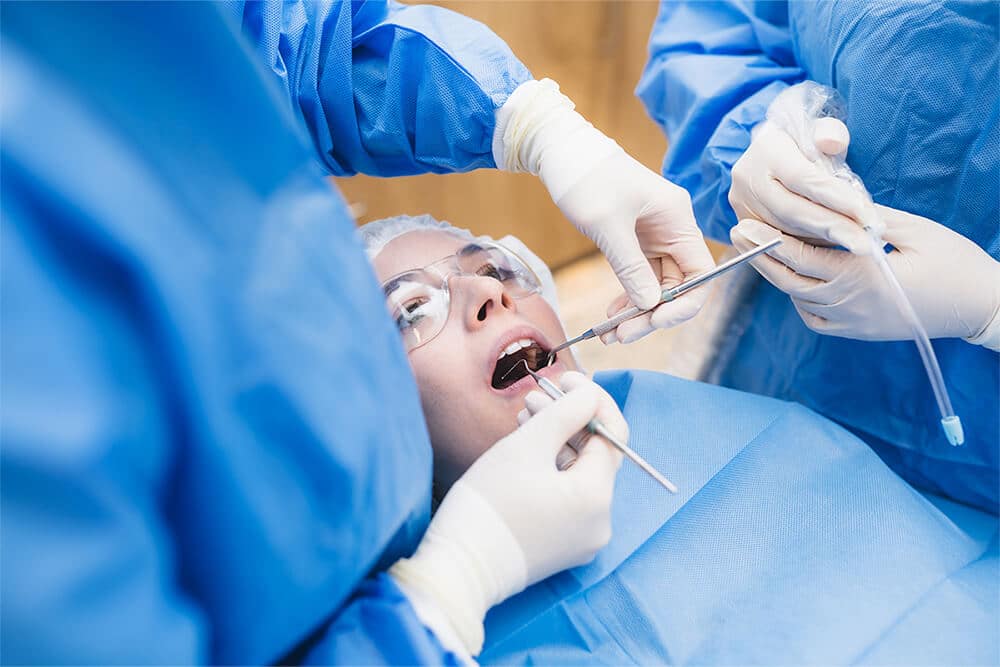 young woman sitting in dental chair at dental clinic while doctors examining her teeth